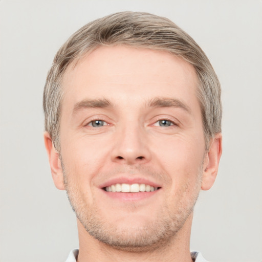 Joyful white adult male with short  brown hair and grey eyes