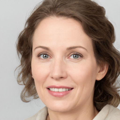 Joyful white adult female with medium  brown hair and grey eyes