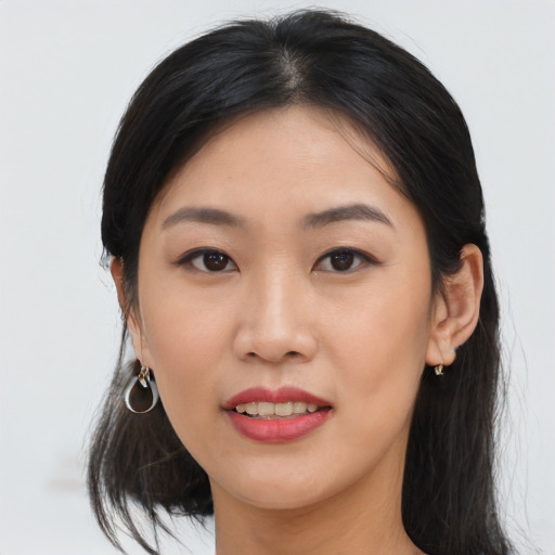 Joyful asian young-adult female with long  black hair and brown eyes