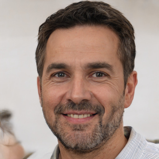 Joyful white adult male with short  brown hair and brown eyes