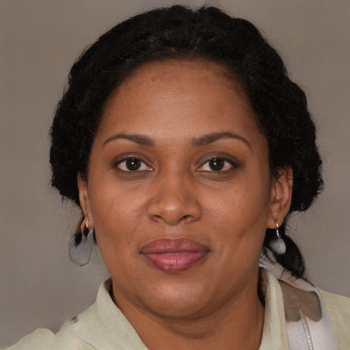 Joyful black adult female with medium  brown hair and brown eyes