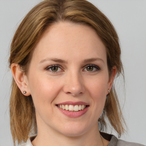 Joyful white young-adult female with medium  brown hair and grey eyes