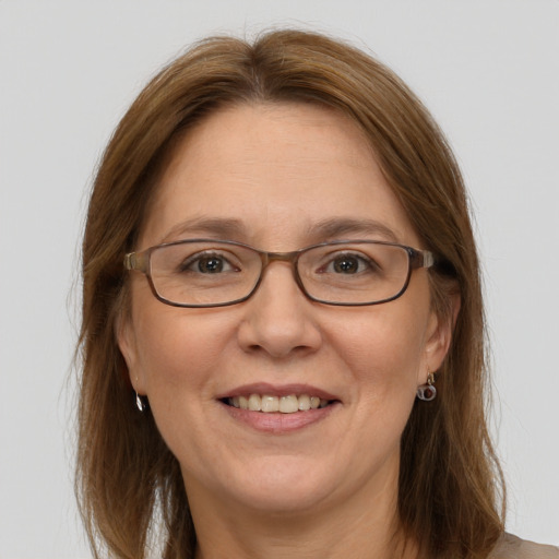 Joyful white adult female with long  brown hair and blue eyes