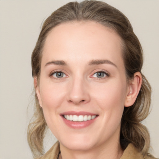 Joyful white young-adult female with medium  brown hair and green eyes