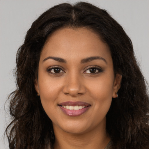 Joyful latino young-adult female with long  brown hair and brown eyes