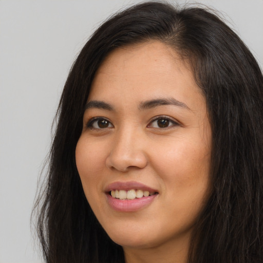 Joyful asian young-adult female with long  brown hair and brown eyes