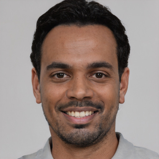Joyful latino young-adult male with short  black hair and brown eyes