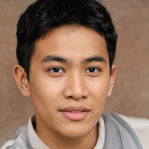 Joyful asian young-adult male with short  brown hair and brown eyes