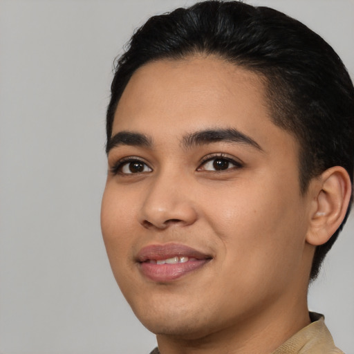 Joyful latino young-adult male with short  black hair and brown eyes