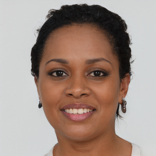 Joyful black young-adult female with short  black hair and brown eyes
