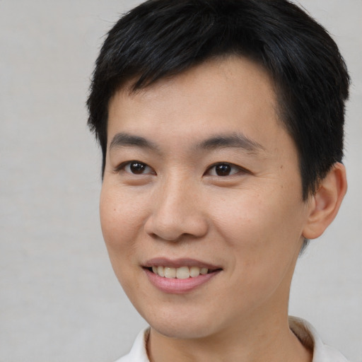 Joyful asian young-adult male with short  brown hair and brown eyes