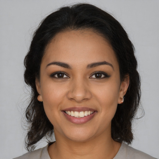 Joyful latino young-adult female with medium  brown hair and brown eyes