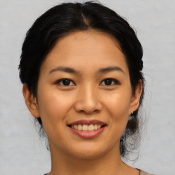 Joyful asian young-adult female with medium  brown hair and brown eyes