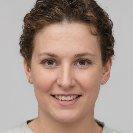 Joyful white young-adult female with short  brown hair and grey eyes