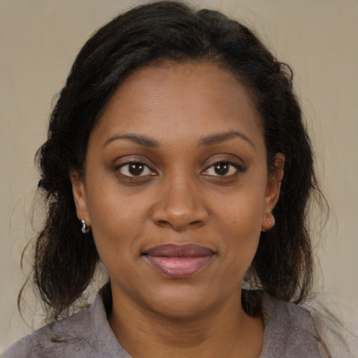 Joyful black adult female with medium  brown hair and brown eyes