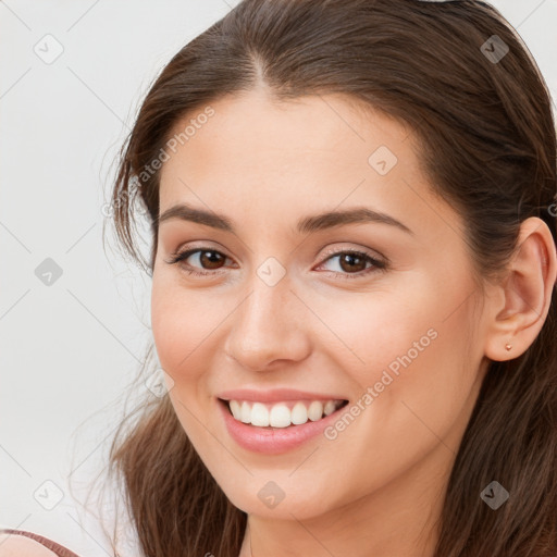 Joyful white young-adult female with long  brown hair and brown eyes