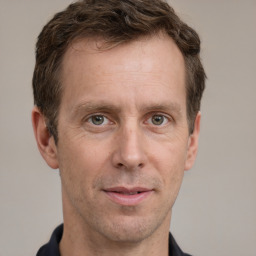 Joyful white adult male with short  brown hair and grey eyes