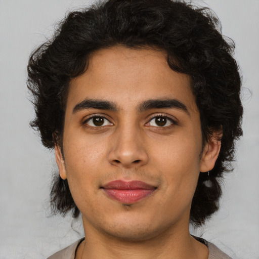 Joyful latino young-adult male with short  brown hair and brown eyes