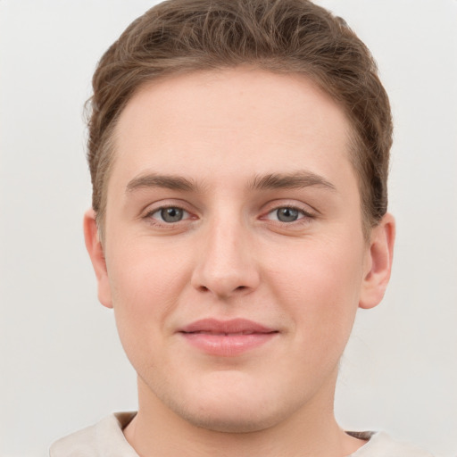 Joyful white young-adult male with short  brown hair and grey eyes