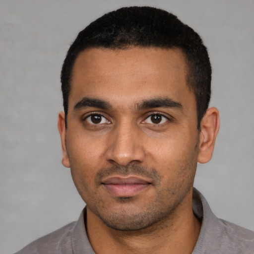 Joyful latino young-adult male with short  black hair and brown eyes