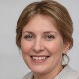 Joyful white adult female with medium  brown hair and grey eyes