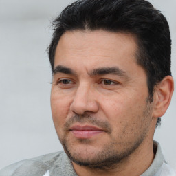 Joyful white adult male with short  black hair and brown eyes