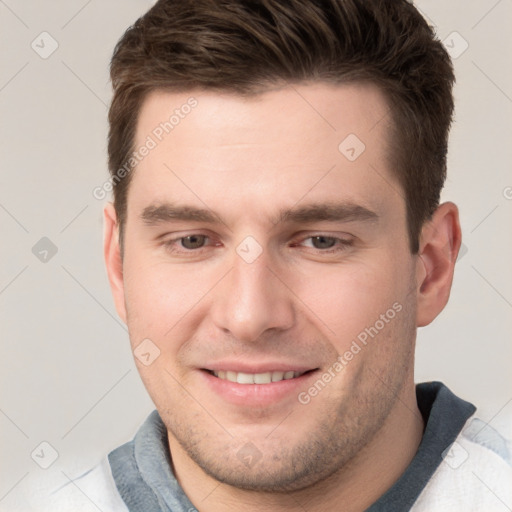 Joyful white young-adult male with short  brown hair and grey eyes