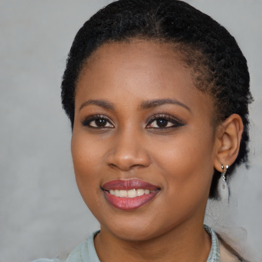 Joyful black young-adult female with short  brown hair and brown eyes