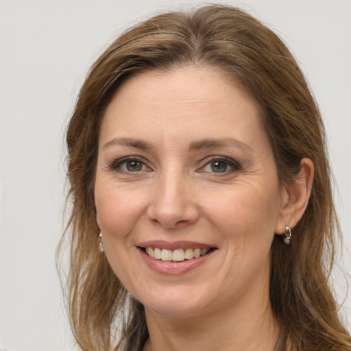 Joyful white adult female with long  brown hair and brown eyes