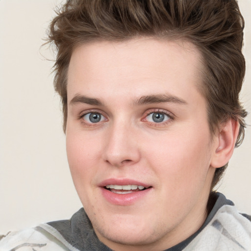 Joyful white young-adult male with short  brown hair and blue eyes