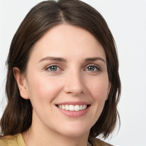 Joyful white young-adult female with medium  brown hair and grey eyes