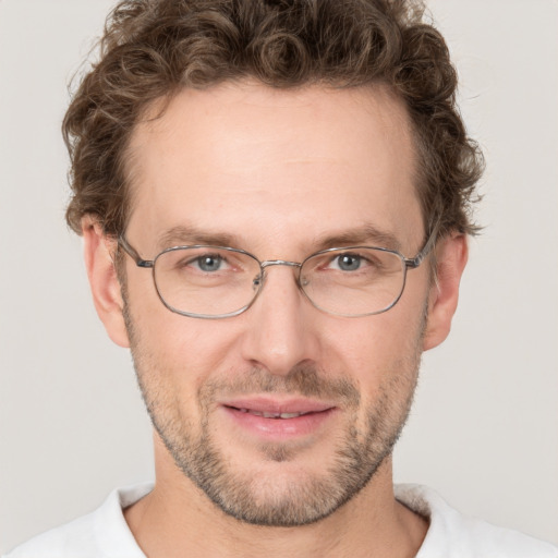 Joyful white adult male with short  brown hair and blue eyes