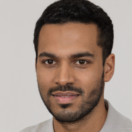 Joyful black young-adult male with short  black hair and brown eyes