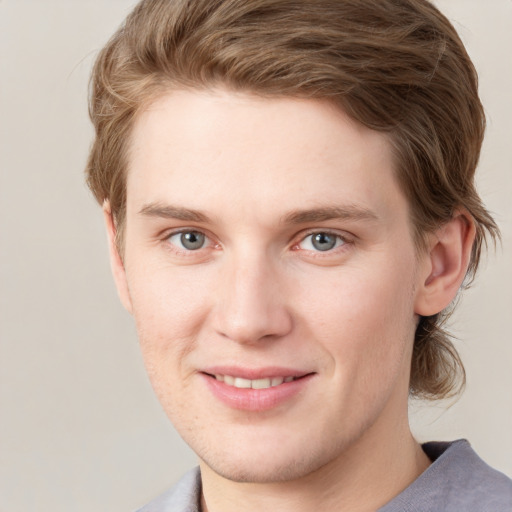 Joyful white young-adult male with short  brown hair and blue eyes