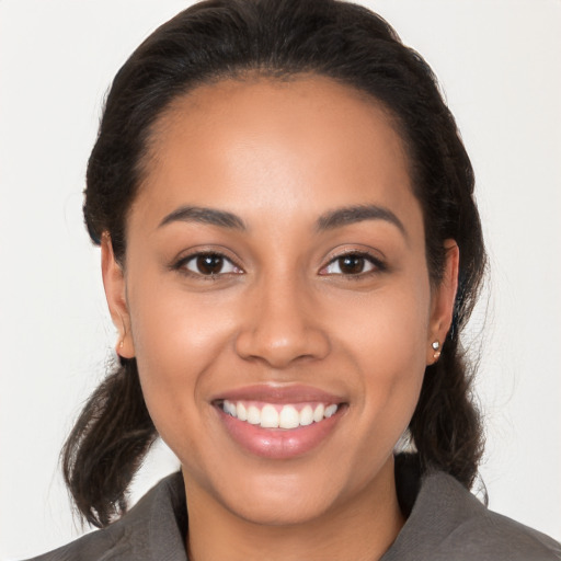 Joyful latino young-adult female with medium  brown hair and brown eyes