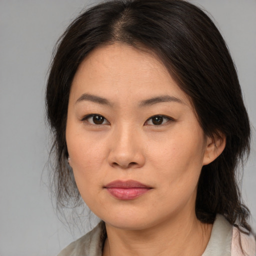 Joyful asian young-adult female with medium  brown hair and brown eyes