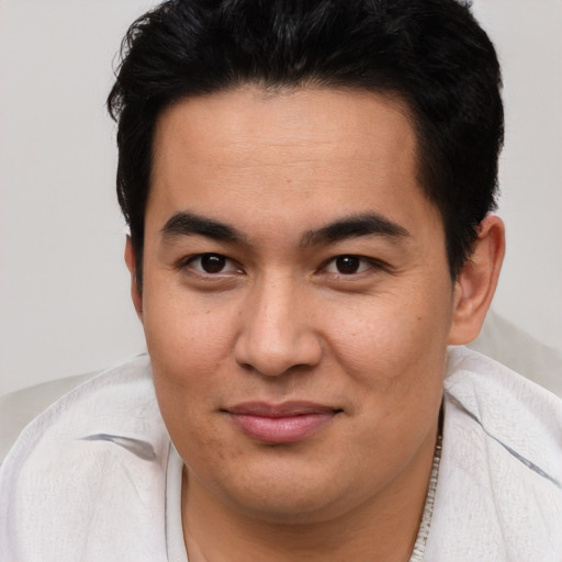 Joyful latino young-adult male with short  brown hair and brown eyes