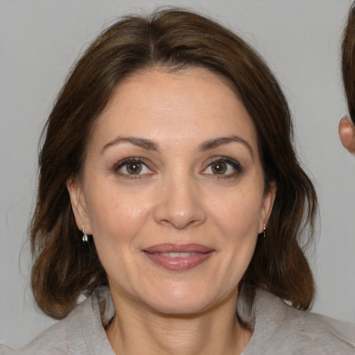 Joyful white adult female with medium  brown hair and brown eyes