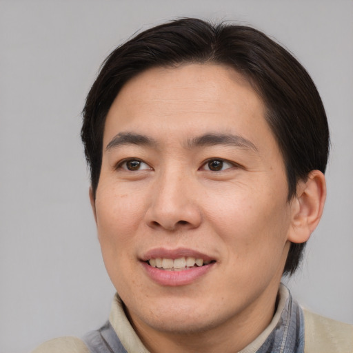Joyful asian adult male with medium  brown hair and brown eyes
