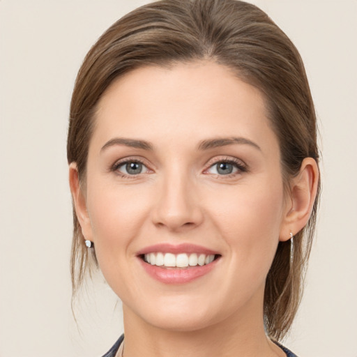 Joyful white young-adult female with medium  brown hair and grey eyes