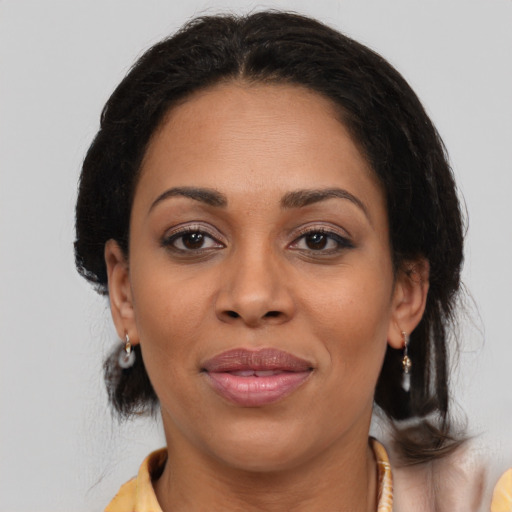 Joyful latino adult female with medium  brown hair and brown eyes