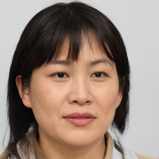 Joyful asian adult female with medium  brown hair and brown eyes