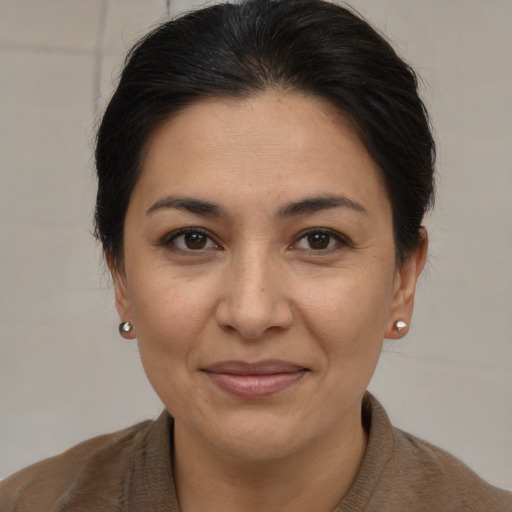Joyful latino adult female with medium  brown hair and brown eyes