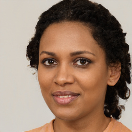 Joyful black young-adult female with medium  black hair and brown eyes