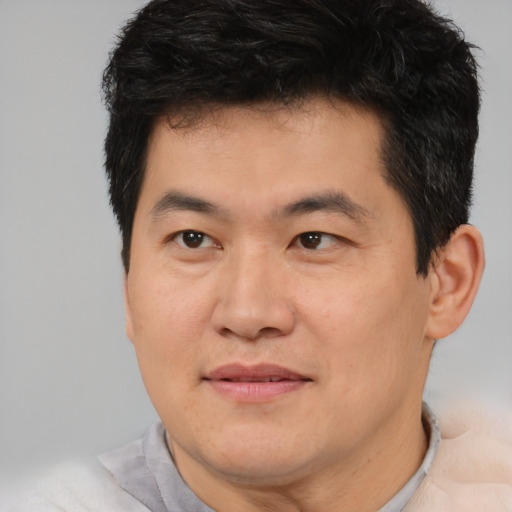 Joyful asian young-adult male with short  brown hair and brown eyes