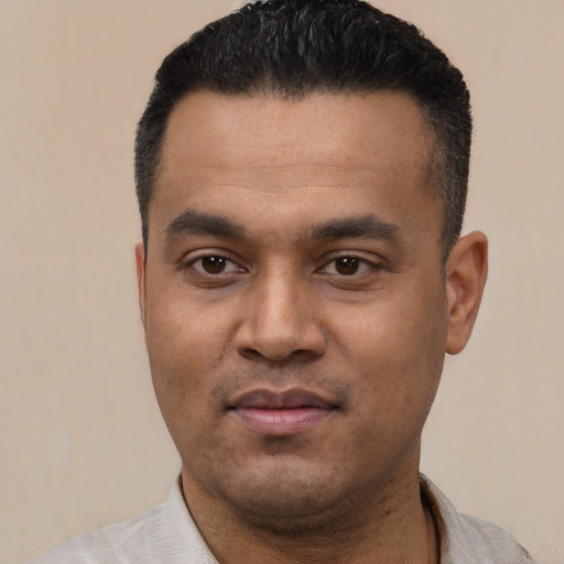 Joyful latino young-adult male with short  black hair and brown eyes
