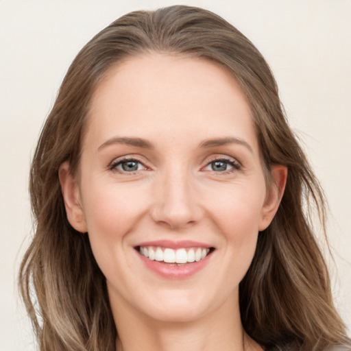 Joyful white young-adult female with long  brown hair and blue eyes