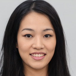 Joyful asian young-adult female with long  brown hair and brown eyes