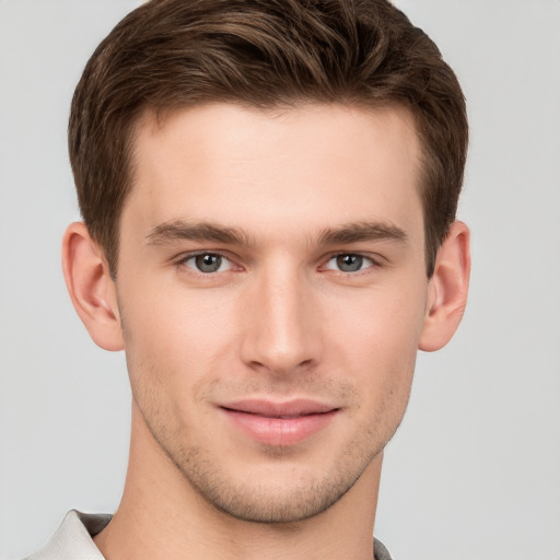 Joyful white young-adult male with short  brown hair and grey eyes