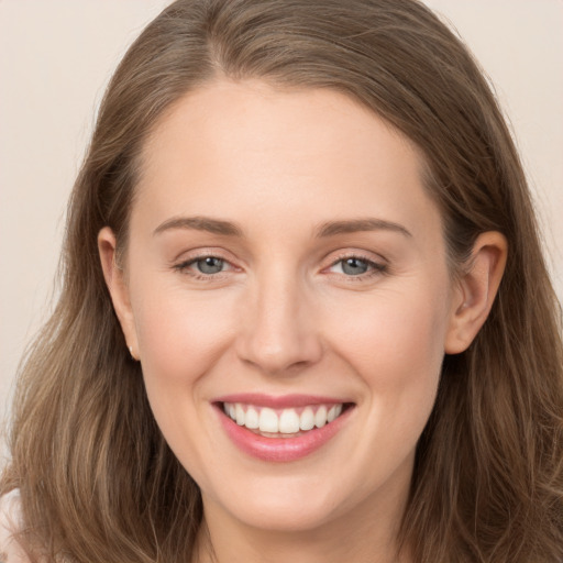 Joyful white young-adult female with long  brown hair and grey eyes